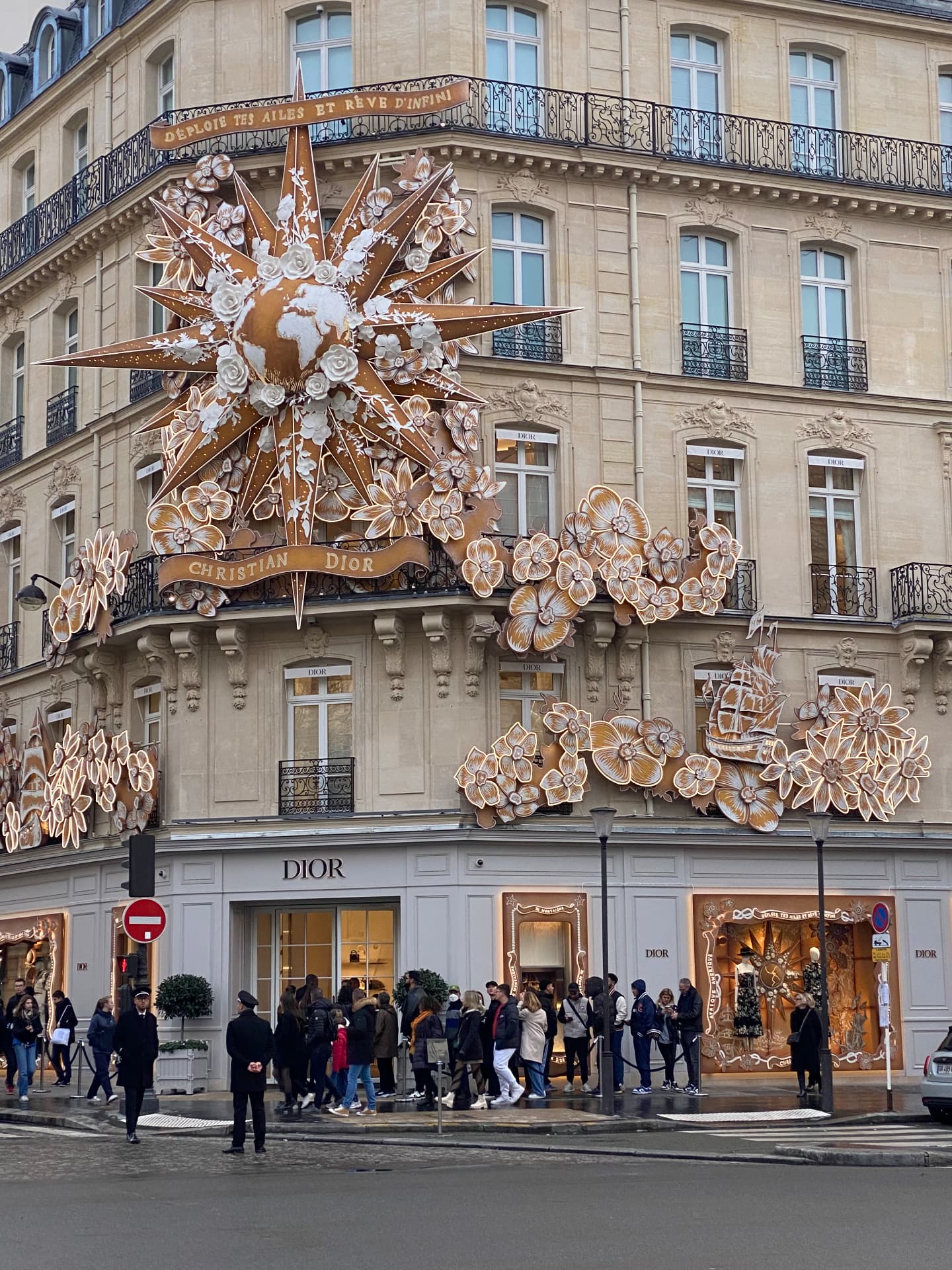 Queue beneath illuminated Christmas decorations in Paris